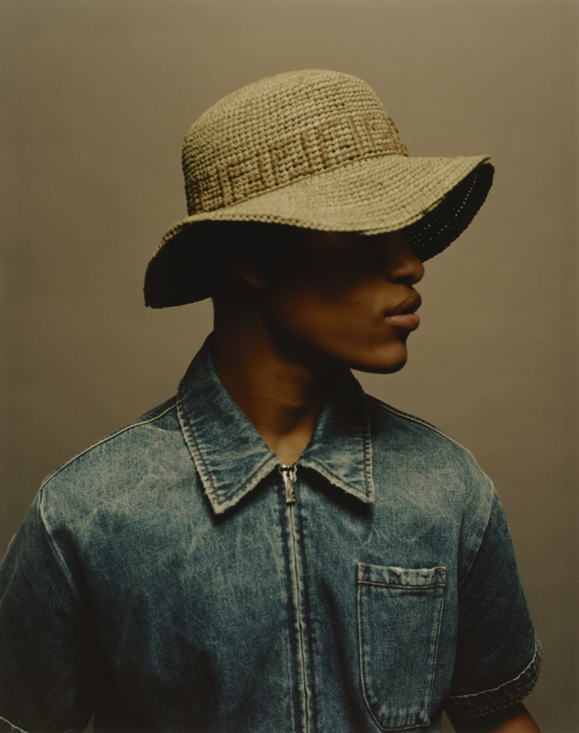 Fendi fashion editorial taken from out Spring issue model wears Fendi sunhat and denim shirt