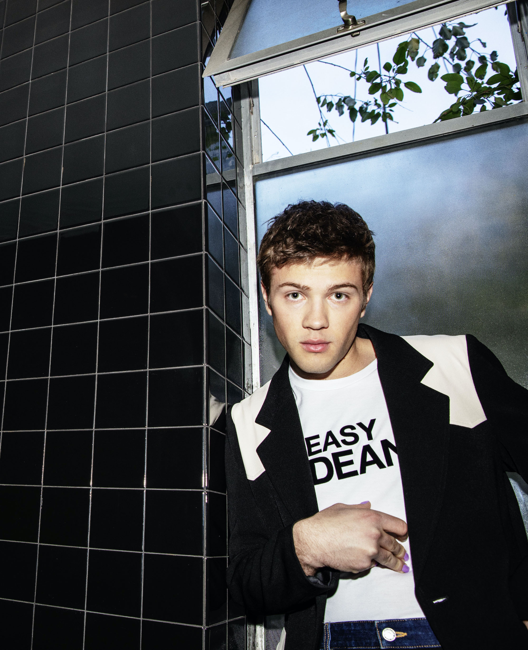 Connor Jessup in black and white suit with tie