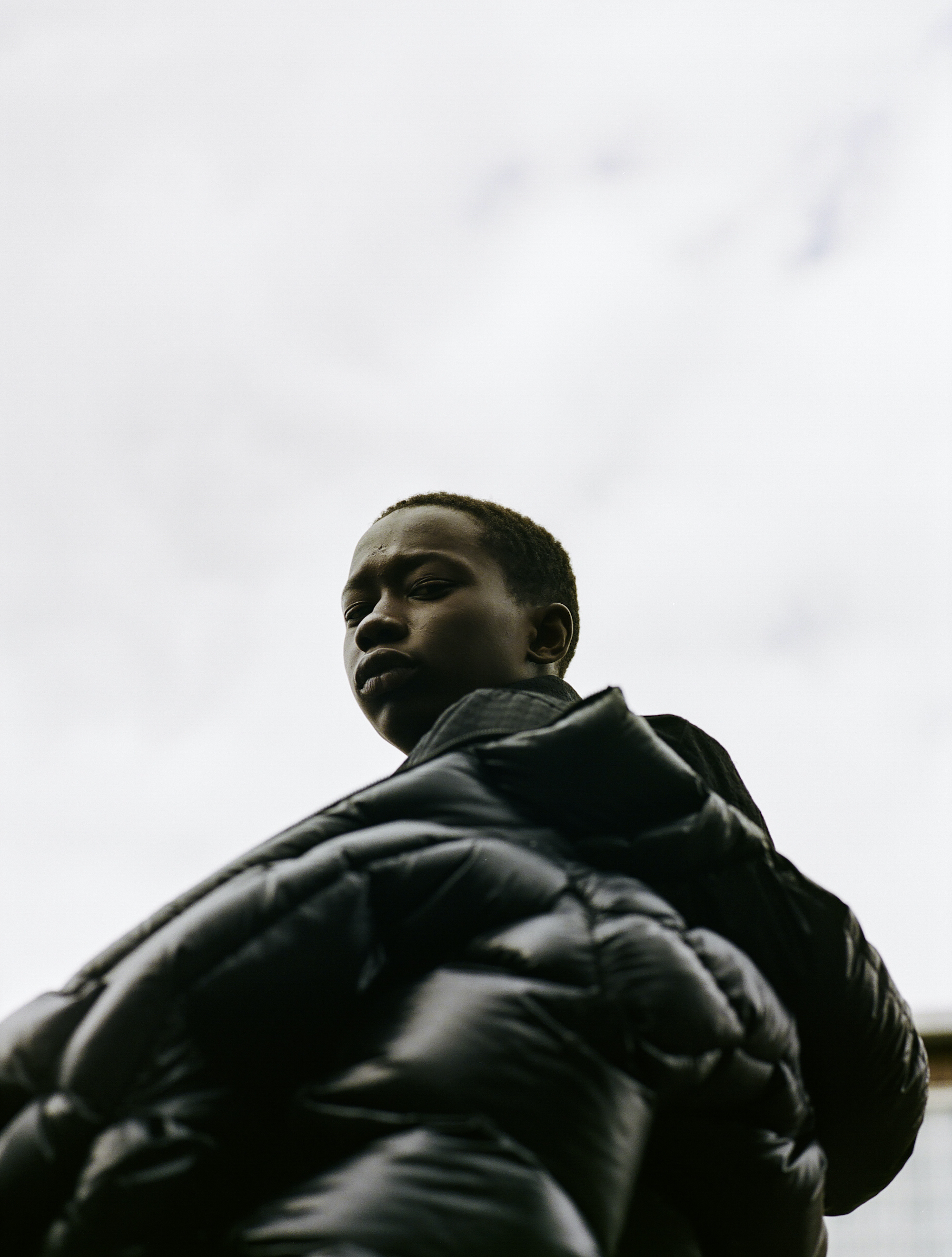 Model wearing black shiny jacket